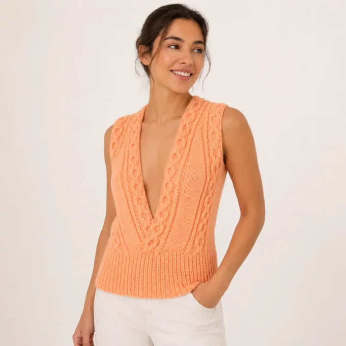 Vue de trois-quarts d'un débardeur en tricot couleur pêche corail pastel avec décolleté V profond et