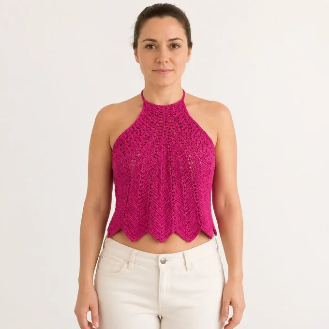 Crop top dos nu halter en crochet rose fuchsia a motifs ajoures porte par une femme
