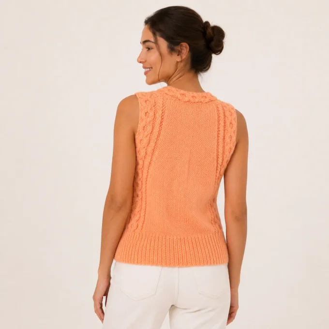 Vue de dos d'un pull sans manches en tricot couleur pêche abricot avec finitions torsadées sur les é