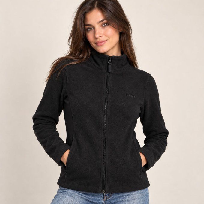 Modèle femme portant la veste polaire noire zippée Reebok vue de face.